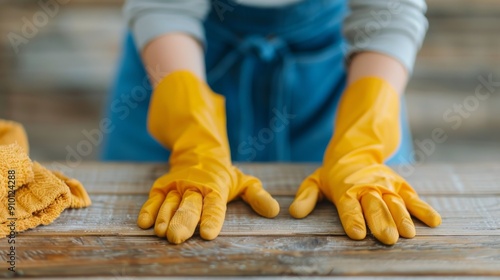 Woman Wearing Yellow Gloves Preparing to Clean a Wooden Table Indoors