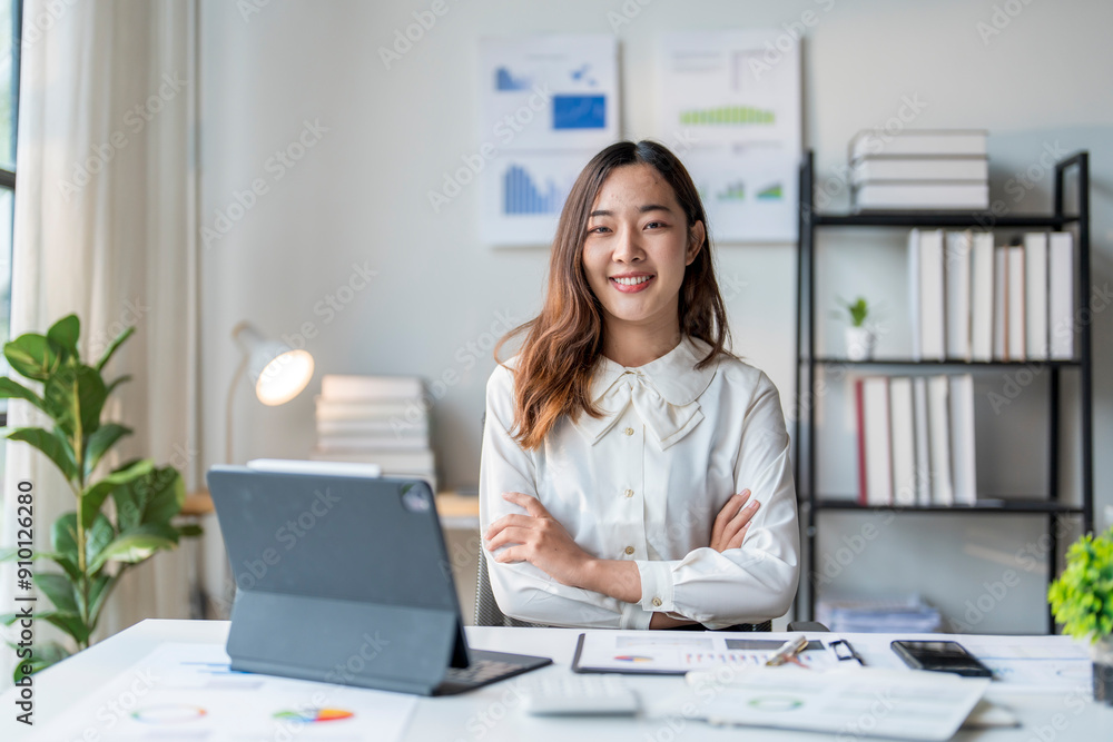 Young asian businesswoman sitting with arms crossed at office desk Young asian businesswoman sitting with arms crossed at office desk