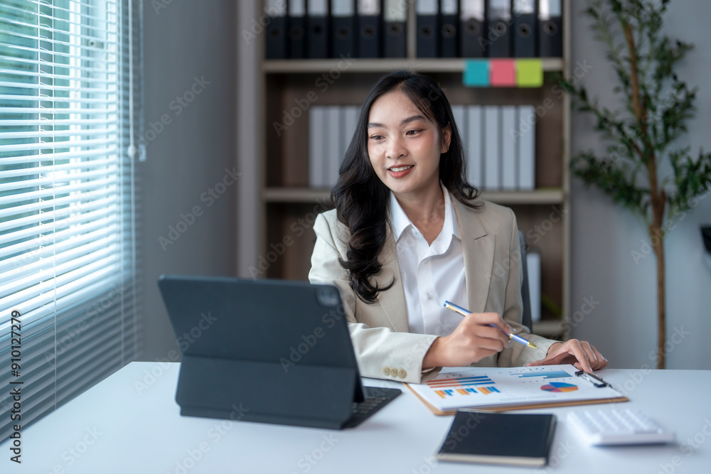 Businesswoman is using a tablet for a video conference and analyzing financial graphs Businesswoman is using a tablet for a video conference and analyzing financial graphs