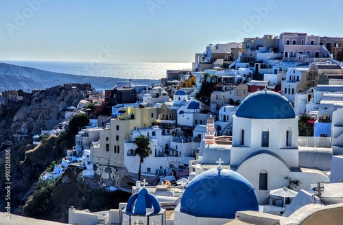 Картината върху платно A stunning view of Santorini's iconic whitewashed buildings with blue domes overlooking the sparkling Aegean Sea, capturing the island's traditional Cycladic architecture and coastal beauty