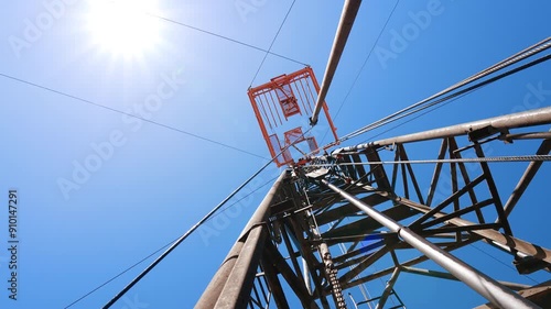 Standing at the foot of the derrick for drilling oil. Low angle view at the tower with boer producing oil. photo