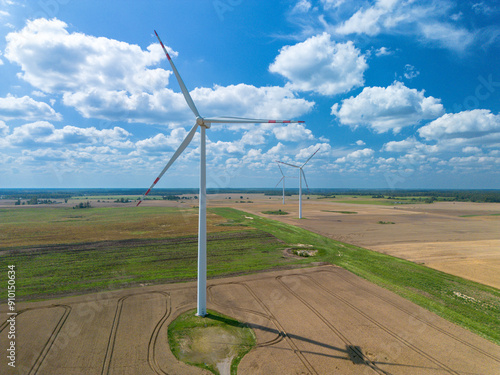 Drone view Windmills wind turbines farm power generators landscape blue sky in beautiful nature landscape for production of renewable green energy. Eco friendly. Poland, Europe, aerial photography