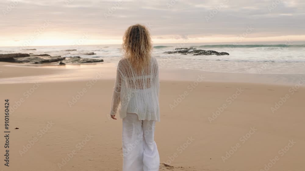 Solitary woman enjoys a peaceful walk along the shoreline, basking in the beauty of a seaside sunset. Solitary woman enjoys a peaceful walk along the shoreline, basking in the beauty of a seaside sunset.
