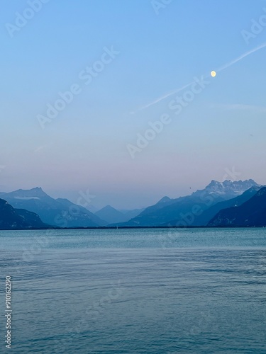 Lake Geneva and Swiss Alps landscape view at dusk with the moon in the sky.  No people. 