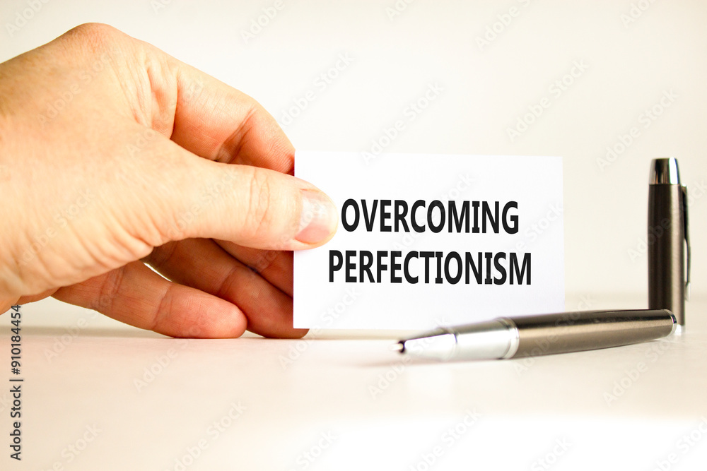Overcoming perfectionism symbol. Concept words Overcoming perfectionism on beautiful white paper. Beautiful white background. Businessman hand. Business Overcoming perfectionism concept. Copy space. Overcoming perfectionism symbol. Concept words Overcoming perfectionism on beautiful white paper. Beautiful white background. Businessman hand. Business Overcoming perfectionism concept. Copy space.