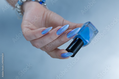 Woman's beautiful hand with long nails and light baby blue manicure 