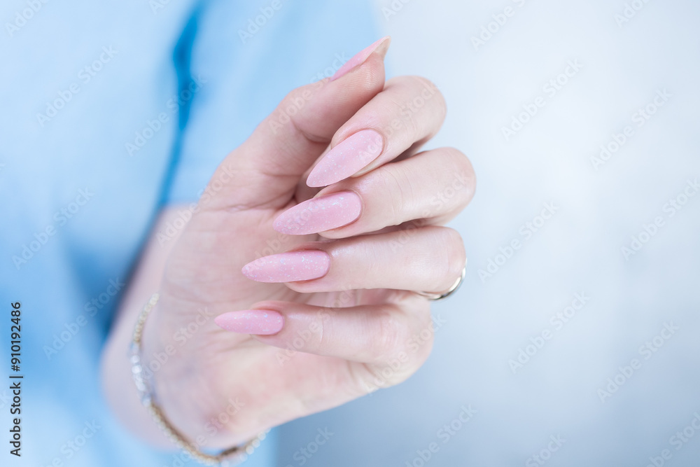 Woman's hands with long nails and a light pink color nail polish Woman's hands with long nails and a light pink color nail polish