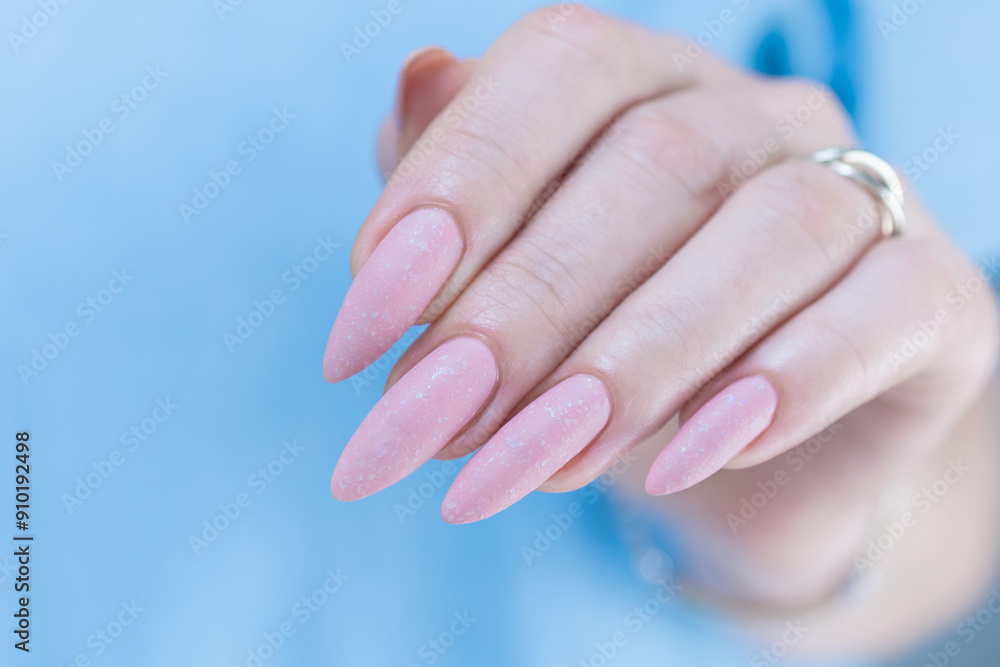 Woman's hands with long nails and a light pink color nail polish Woman's hands with long nails and a light pink color nail polish