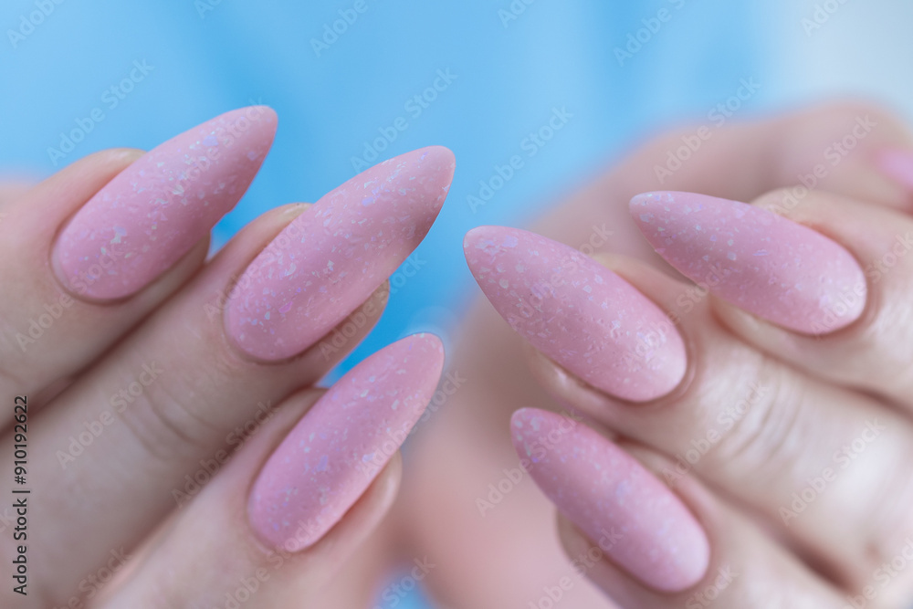 Woman's hands with long nails and a light pink color nail polish Woman's hands with long nails and a light pink color nail polish