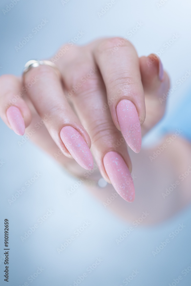 Woman's hands with long nails and a light pink color nail polish Woman's hands with long nails and a light pink color nail polish