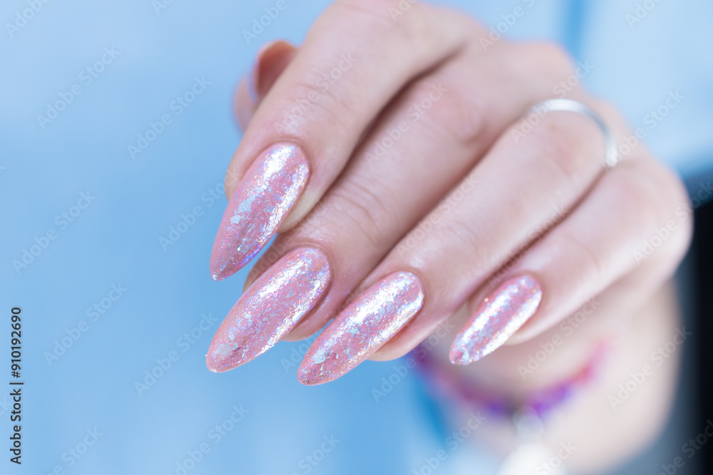 Woman's hands with long nails and a light pink color nail polish Woman's hands with long nails and a light pink color nail polish