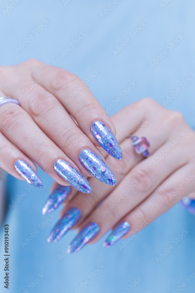 Fototapeta premium Woman's beautiful hand with long nails and bright blue manicure