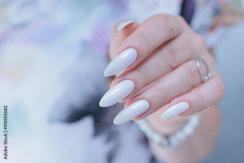 Woman's hands with long nails and a light white color nail polish Woman's hands with long nails and a light white color nail polish