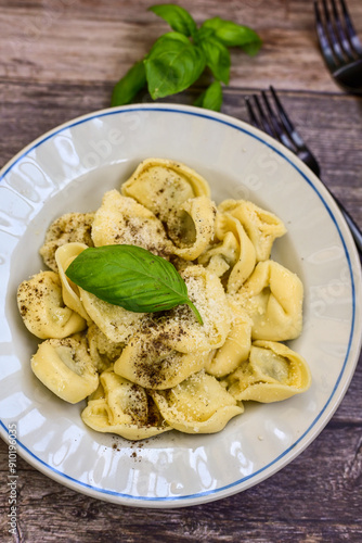 Home made Italian Tortelloni bolognese with parmesan cheese filled with beef , tomato and mozzarella cheese, decorated with fresh basil