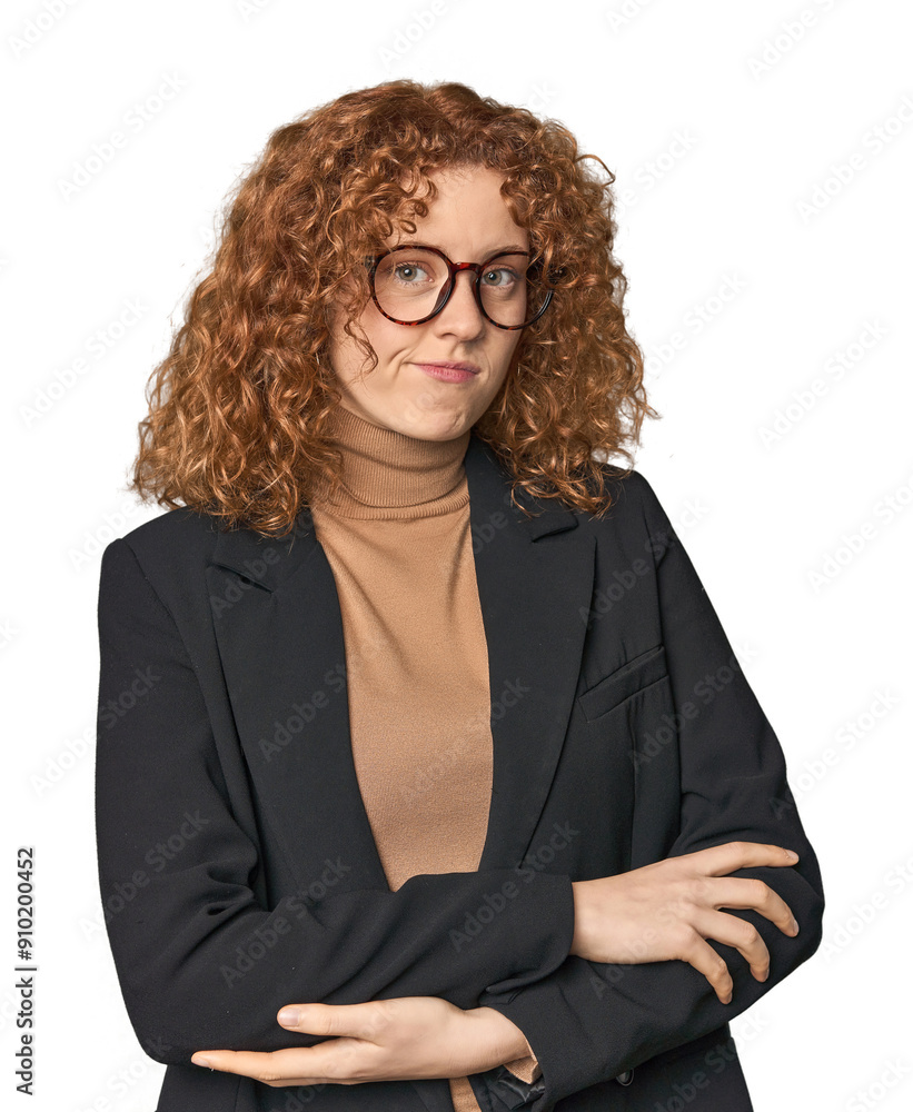 Young Caucasian redhead in business attire suspicious, uncertain, examining you. Young Caucasian redhead in business attire suspicious, uncertain, examining you.