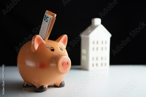 Wallpaper Mural Several euro bills placed in a piggy bank in front of a residential building as a savings concept Torontodigital.ca