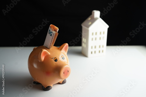 Wallpaper Mural Horizontal photo of several Euro bills placed in a piggy bank in front of a residential building as a concept of saving for the purchase of a home Torontodigital.ca