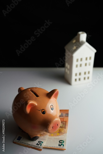 Wallpaper Mural Vertical photo of a piggy bank next to several euro bills in front of a residential building as a concept of saving for the purchase of a home Torontodigital.ca