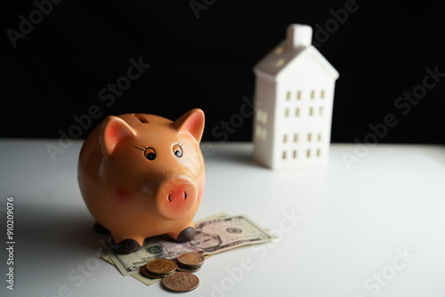 Wallpaper Mural Horizontal photo of various dollar bills and coins in a piggy bank in front of a residential building as a savings concept Torontodigital.ca