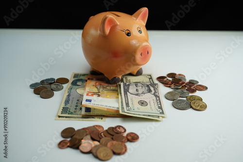 Wallpaper Mural Horizontal photo of a piggy bank on several dollar, euro and yen bills and surrounded by coins of different currencies as a concept of buying and saving foreign currency Torontodigital.ca