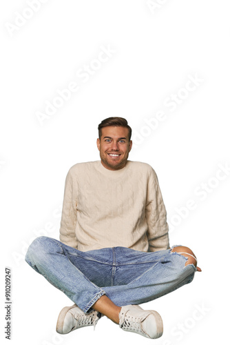 Young Caucasian man sitting on the floor in a studio setting