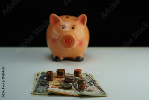 Wallpaper Mural Several dollar, euro and yen bills surrounded by coins of different currencies with a piggy bank out of focus in the background as a concept of saving and buying foreign currency Torontodigital.ca