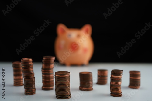 Wallpaper Mural general view with detail of stacked coins of different currencies in front of an out-of-focus piggy bank in the background as a concept of saving for home purchase Torontodigital.ca