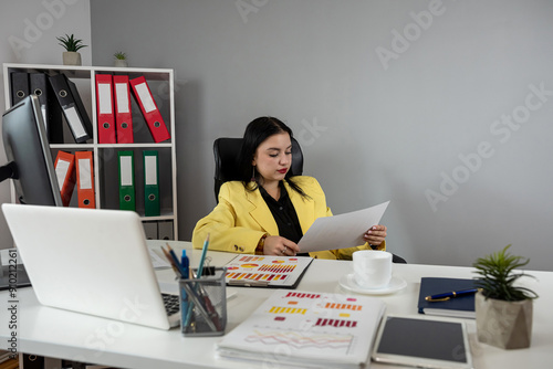 Portrait of young caucaasian woman work at business documents, computer  at office photo