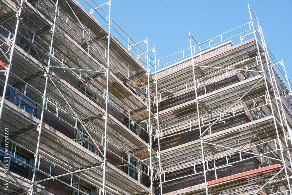 Scaffolding background. Construction site of an apartment block in progress. Raw state concrete structures. Industrial background framework and building materials used. Urban development. Scaffolding background. Construction site of an apartment block in progress. Raw state concrete structures. Industrial background framework and building materials used. Urban development.