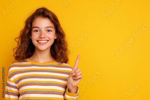 Cheerful Girl, Smiling girl in striped sweater pointing up, Youthful Happiness.