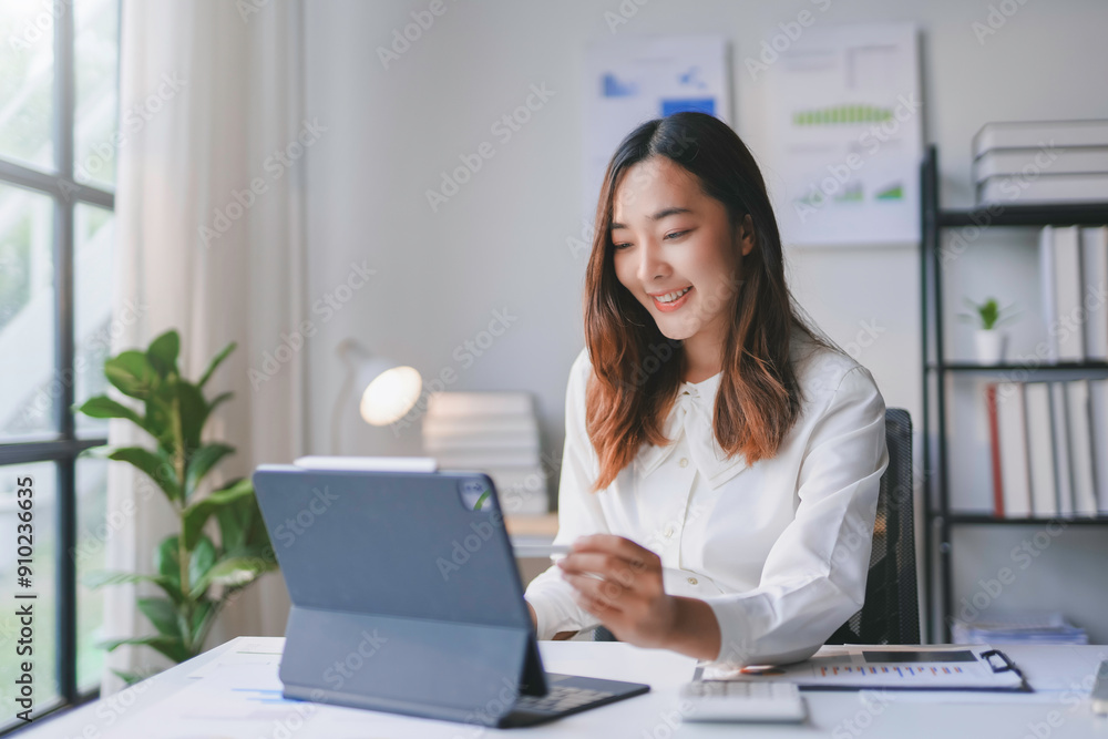 Young asian businesswoman smiling and working online with digital tablet at home office Young asian businesswoman smiling and working online with digital tablet at home office