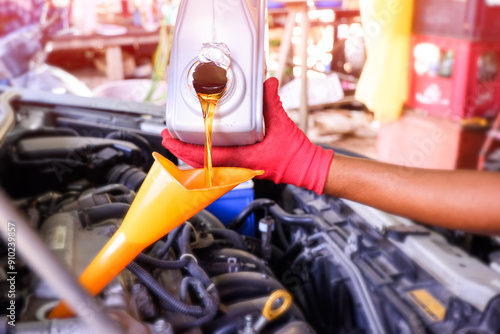 Adding new oil to the engine car through the oil funnel photo