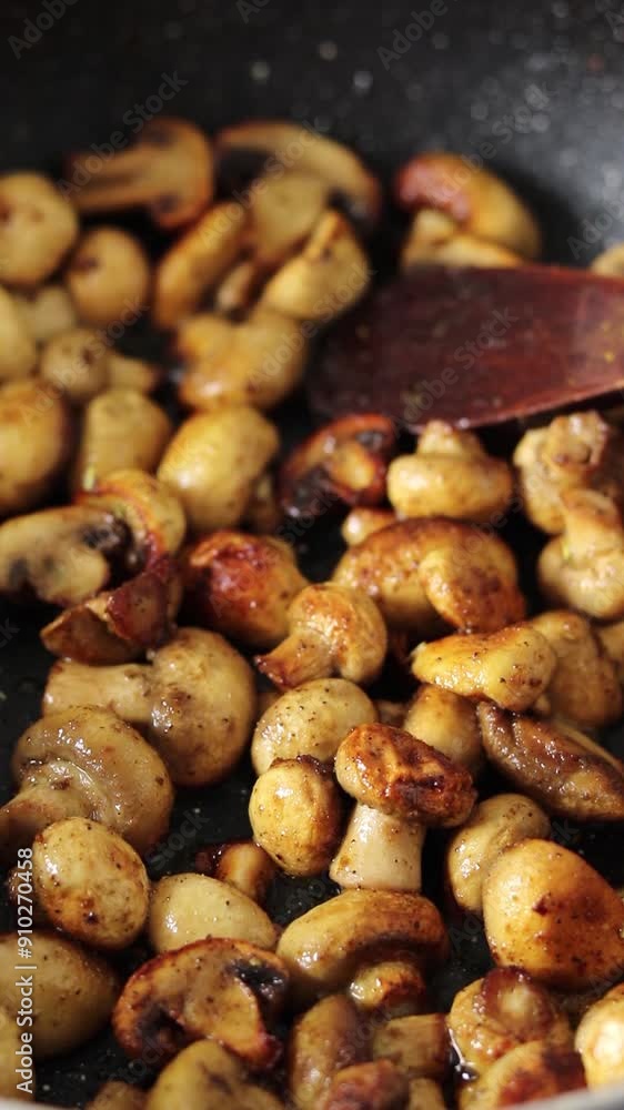Champignon mushrooms are frying in pan with cooking oil. Vertical video. Close-up. Preparation of healthy homemade food. Champignon mushrooms are frying in pan with cooking oil. Vertical video. Close-up. Preparation of healthy homemade food.