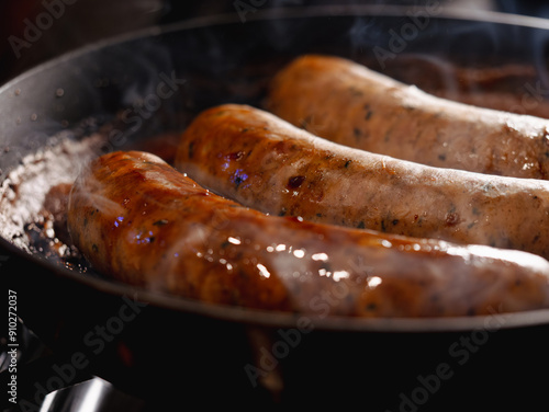 Sausages cooking in beer in a skillet at night 