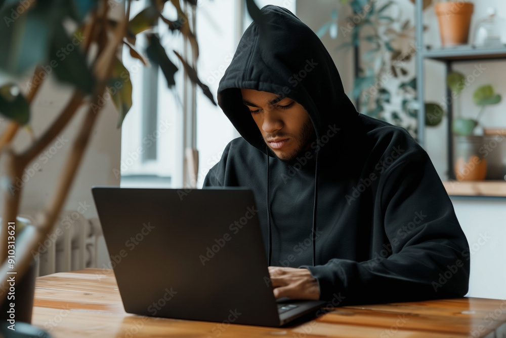Hacker in Black Hoodie Working on Laptop at Desk Hacker in Black Hoodie Working on Laptop at Desk