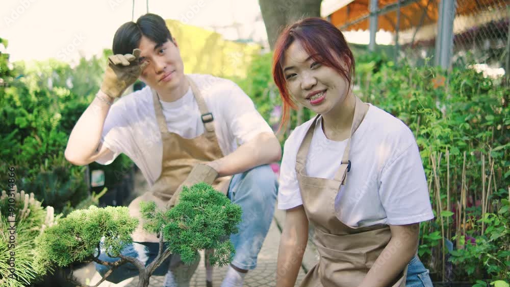 Japanese family, husband and wife, smiling at the camera while sitting in their garden with a bonsai tree, showing joy and togetherness. Japanese family, husband and wife, smiling at the camera while sitting in their garden with a bonsai tree, showing joy and togetherness.