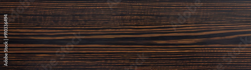 The wenge wood grain background showcases a deep, chocolate-brown hue interwoven with striking black streaks and intricate patterns, creating a visually captivating and luxurious texture