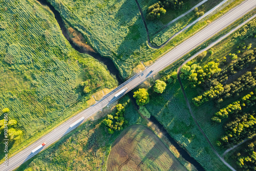 Aerial view of roads, green fields, and a serene waterway highlights the beauty of the landscape