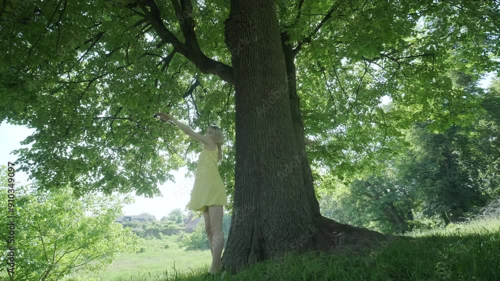 Happy beautiful young girl dancing of freedom in summer park with trees in the background. Happy beautiful young girl dancing of freedom in summer park with trees in the background.