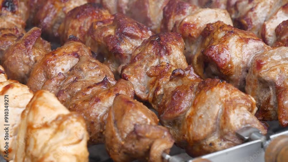 Shish kebabs broil on barbecue. Meat are cooked on hot coals in barbecue, rotates on skewers for roasting. Delicious hot meat Shish kebabs broil on barbecue. Meat are cooked on hot coals in barbecue, rotates on skewers for roasting. Delicious hot meat