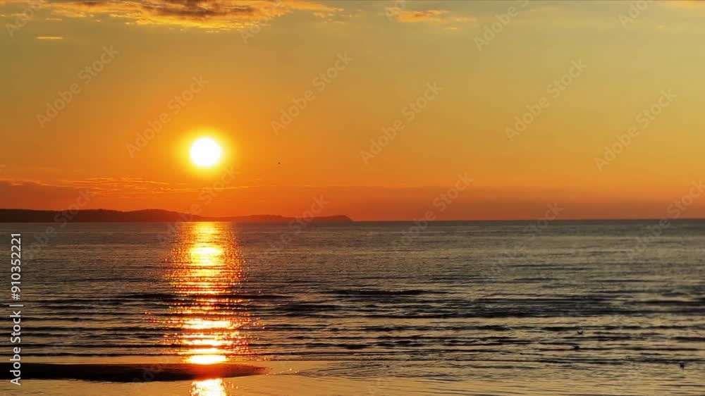 Sunset over the sea. The setting sun over the calm sea. Evening time on the beach by the sea. Sunset over the sea. The setting sun over the calm sea. Evening time on the beach by the sea.