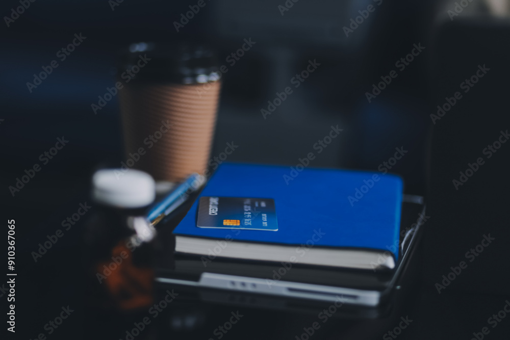 A young Asian female airplane passenger sits by the window during the flight, holding her boarding pass, with her carry-on luggage stored overhead, wearing her seatbelt, and enjoying the journey.