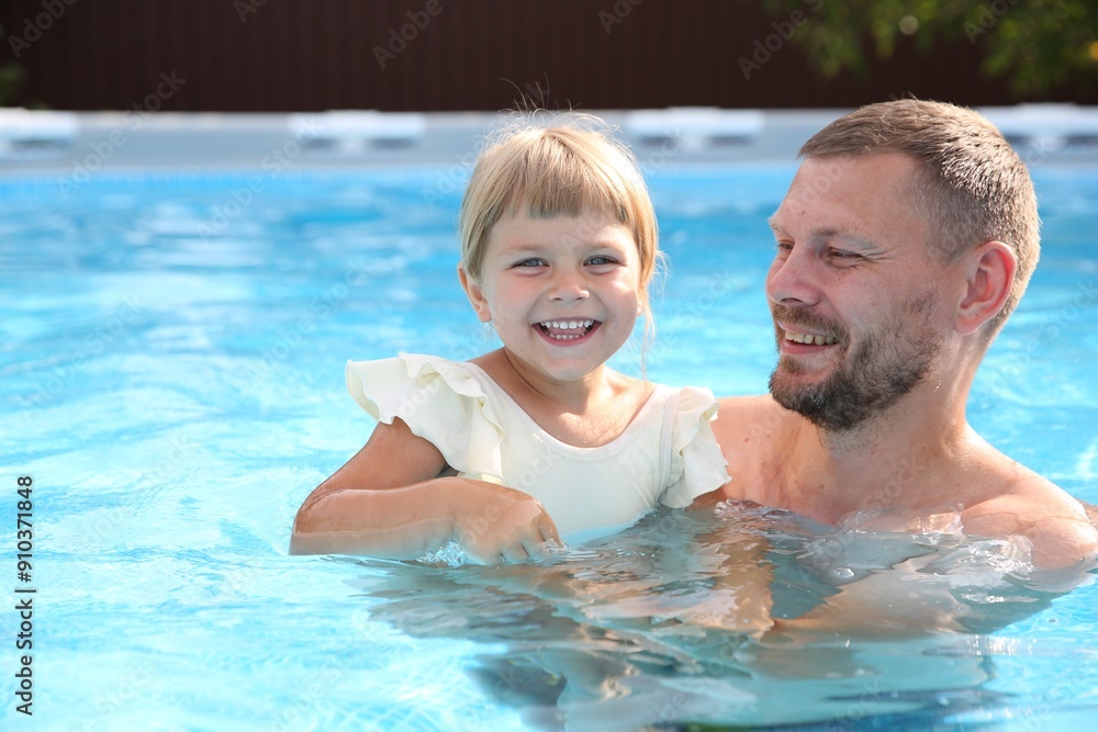 Fototapeta premium Happy father having fun with his daughter in swimming pool