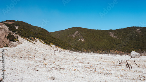 Barren mountain landscape with sparse vegetation under a clear blue sky. Ideal for nature and travel themes photo