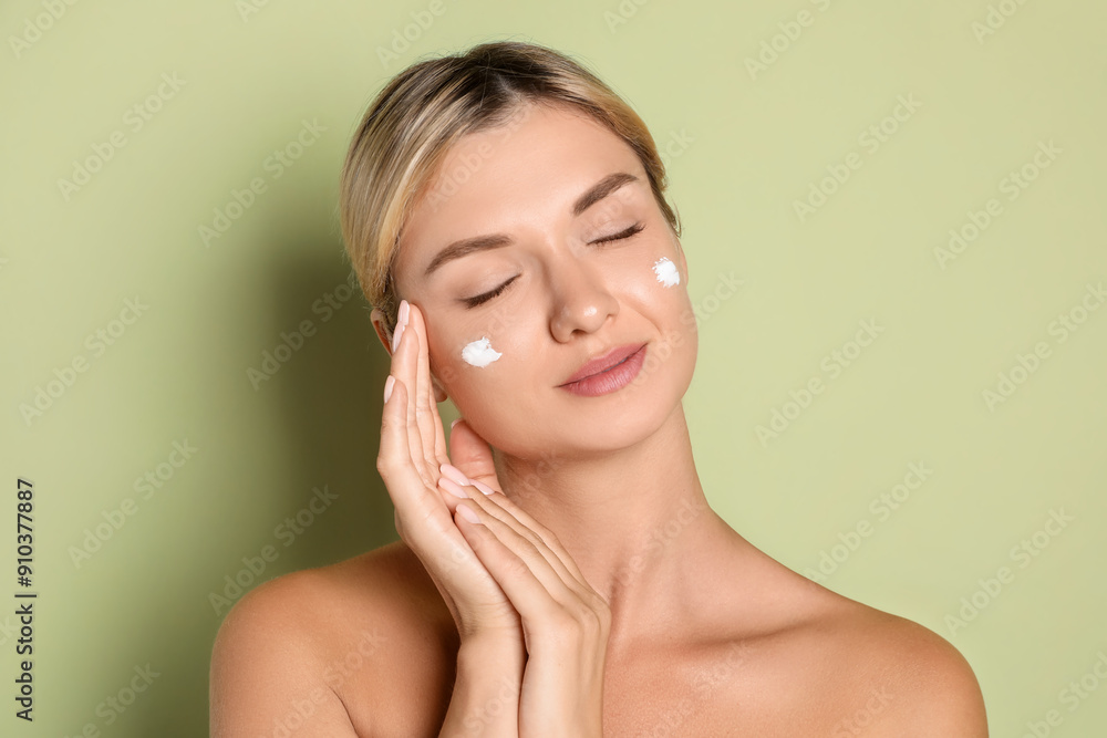 Beautiful woman with cream on her face against green background Beautiful woman with cream on her face against green background