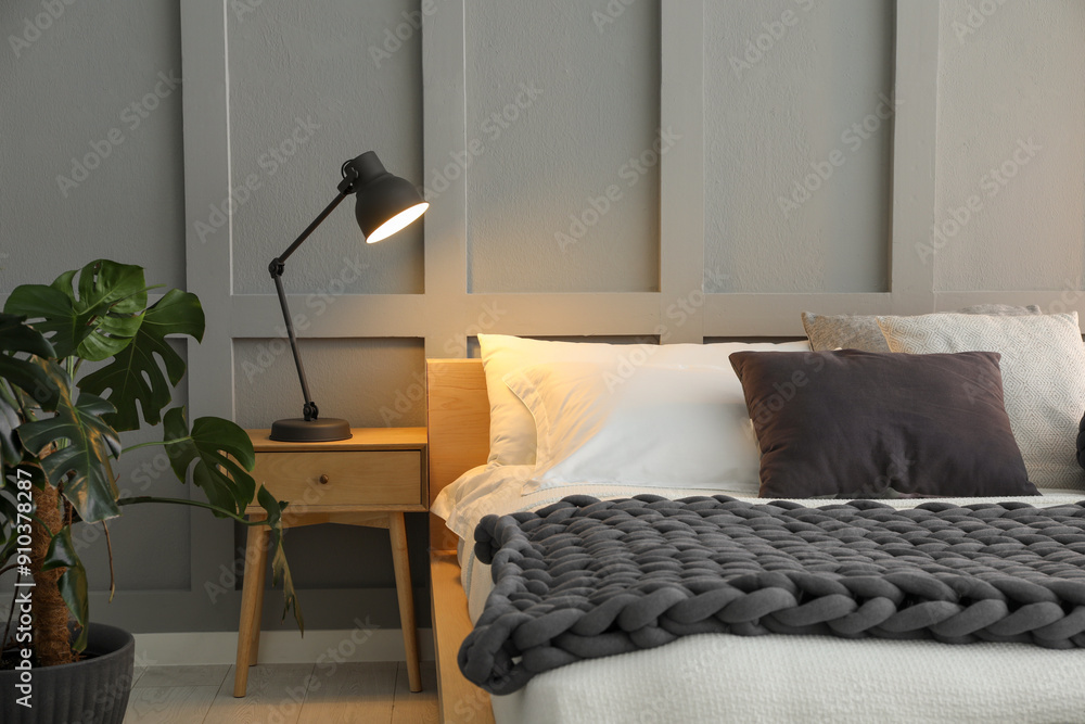 © New Africa - Stylish bedroom interior with comfortable bed, lamps and houseplant