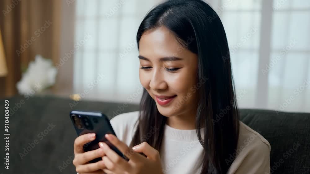 A young woman relaxes on a comfortable couch, engaged in a lively conversation on her phone and radiating joy in a warm living space. A young woman relaxes on a comfortable couch, engaged in a lively conversation on her phone and radiating joy in a warm living space.
