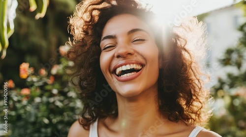 Brightly Smiling Woman With Curly Hair Enjoying a Sunny Day in a Lush Garden