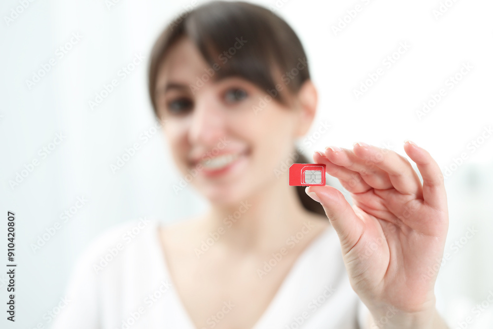 Woman holding SIM card at home, selective focus Woman holding SIM card at home, selective focus