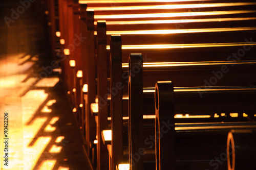 
Rows of church benches. Sunlight filtered through the stained glass window. Selective focus. Religious background. Divine light, grace, hope, miracle concepts